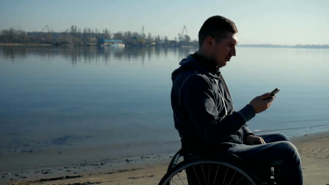 Disabled-man-speaking-on-mobile-phone,-on-wheel-chair