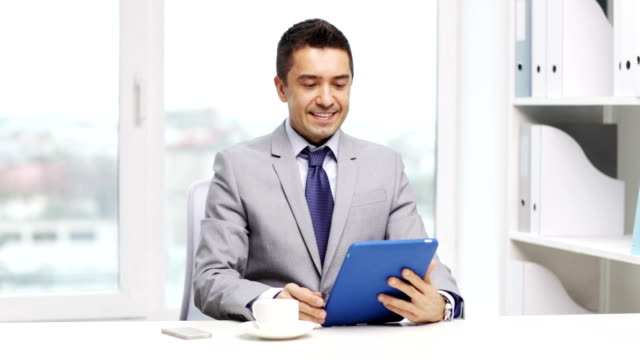 businessman-with-tablet-pc-computer-drinking-coffee-at-office