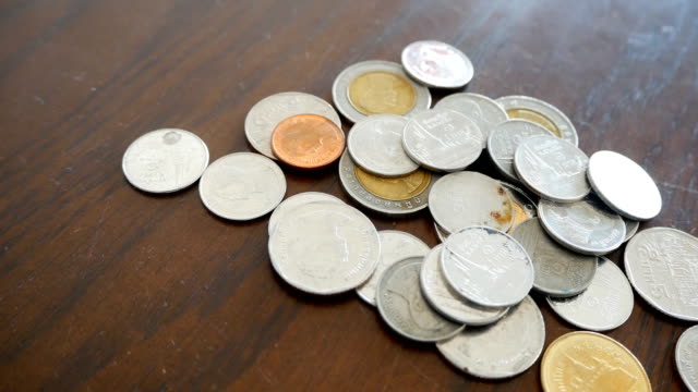 Thailand-Münzen-auf-Holzboden