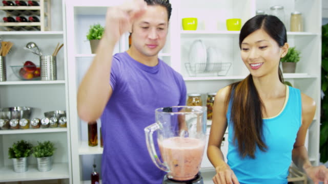 Healthy-Ethnic-couple-blending-homemade-fruit-smoothie-together