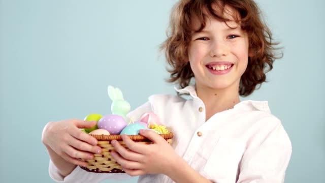 Curly-boy-with-an-Easter-basket.-First-a-serious-look-on-his-face,-then-he-laughs.-Waiting-for-a-holiday