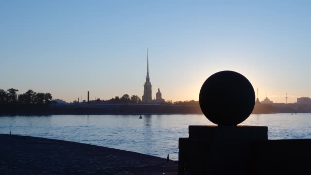 Silhouette-on-stone-ball-on-the-Spit-of-Vasilievsky-Island-on-the-Peter-and-Paul-Fortress-background-early-morning---St.-Petersburg,-Russia