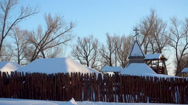 snow-covered-ancient-city-behind-wooden-palisade,-church-in-an-ancient-city