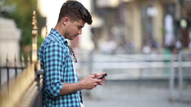 young-man-typing-on-his-mobile-phone