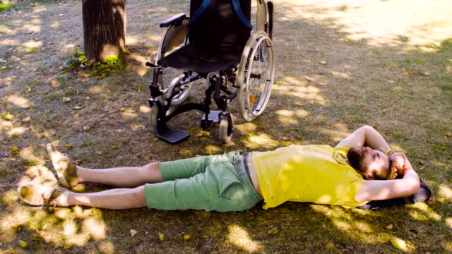 Young-disable-man-is-relaxing-on-the-ground-in-the-park