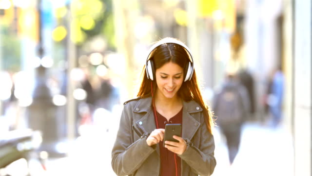Teen-listening-to-music-walking-in-the-street