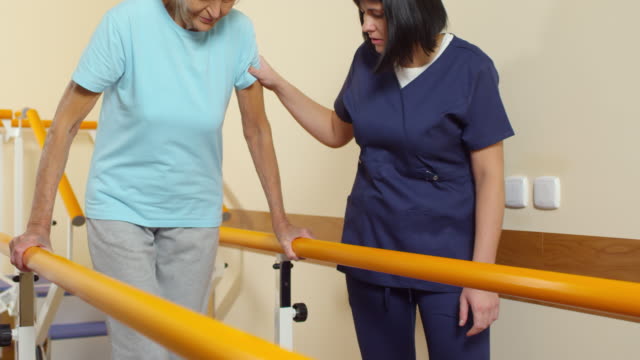 Senior-mujer-aprender-a-caminar-con-fisioterapeuta