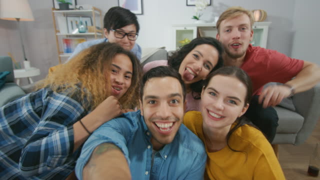 At-Home-Diverse-Group-of-Friends-Doing-Collective-Selfie,-Guy-Lifts-Smartphone-People-Smile,-Laugh-and-do-Duck-Lips.Young-People-Doing-Live-Stream-of-the-Home-Party.