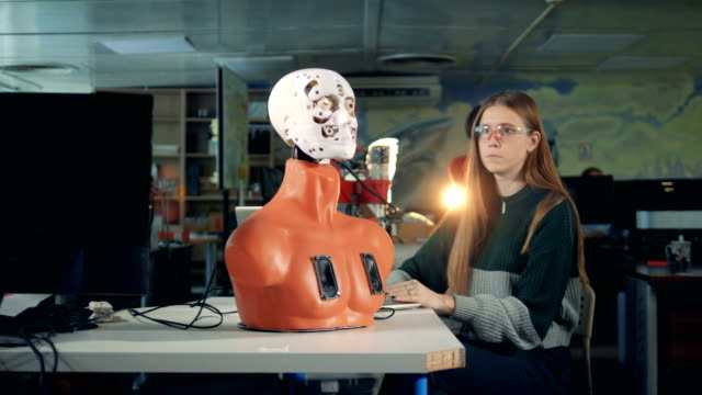 Chica-está-manipulando-la-cara-del-robot-mediante-un-ordenador