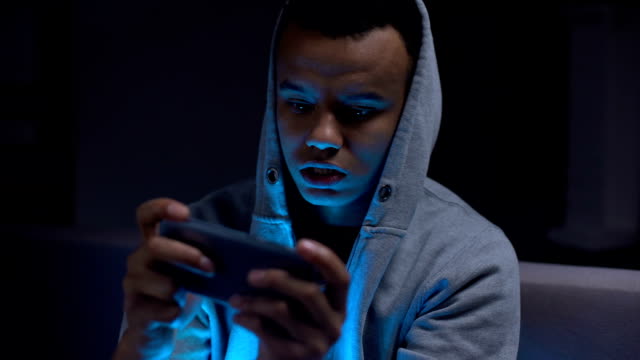 Schwarzer-Teenager,-der-Videospiele-am-Telefon-spielt,-Schaden-für-die-psychische-Gesundheit-und-das-Sehvermögen