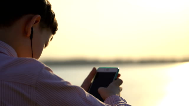 Junge-Kerl-nutzt-eine-Anwendung-auf-Ihrem-Smartphone-oder-klettert-in-sozialen-Netzwerken