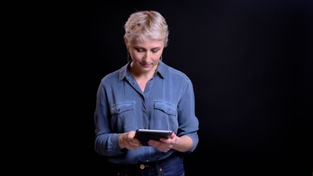 Closeup-portrait-of-modern-caucasian-female-using-a-tablet-looking-at-camera-and-smiling