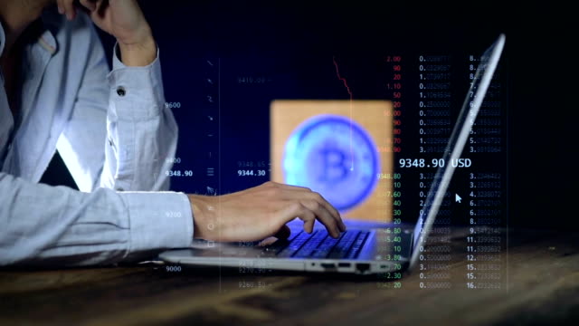 A-man-uses-a-laptop-that-monitors-the-price-of-the-Cripp-currency.-BITCOIN