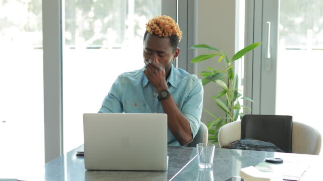 Hombre-de-negocios-afroamericano-usando-computadora-portátil,-tiene-problema-y-llama-a-su-jefe-por-teléfono
