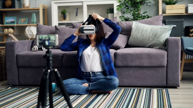 Lindo-Vlogger-grabación-de-vídeo-sobre-VR-gafas-que-llevan-el-dispositivo-y-hablar-en-casa
