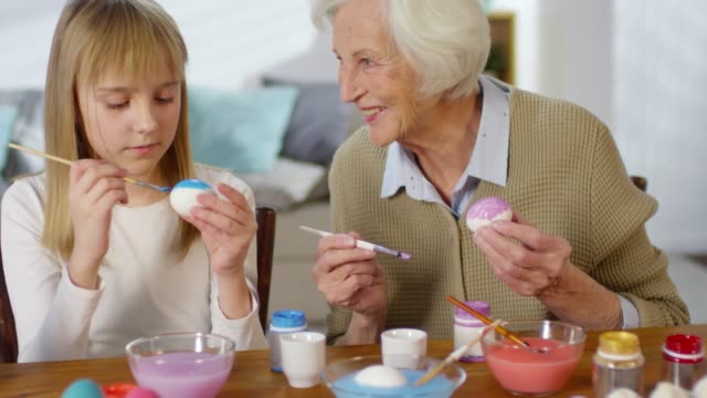 Grandmother-Teaching-Granddaughters-to-Paint-Eggs