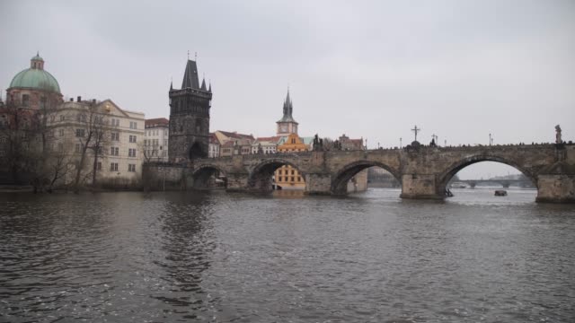 Prag.-Karlsbrücke,-schöne-Kamerabewegung-am-Wasser-entlang.-4K-Slow-Mo