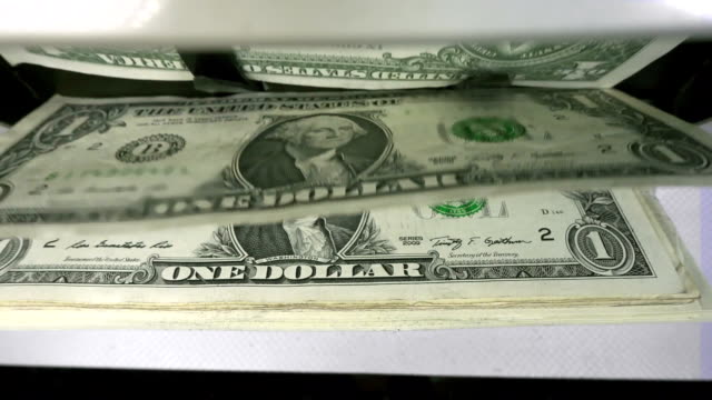 Electronic-money-counter-machine-is-counting-is-counting-the-American-hundred-dollar-US-dollars-banknotes