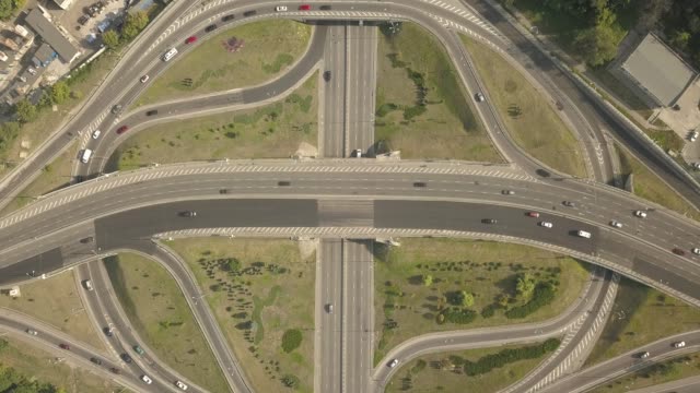 Aerial-high-drone-in-4K-flight-over-evening-road-traffic-in-Kiev,-Ukraine.-Highway-and-overpass-with-cars-and-trucks,-interchange,-two-level-road-junction-in-the-big-city.-Top-view.
