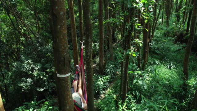 Vista-aérea-de-relajarse-en-la-hamaca-tomando-selfie-con-teléfono-inteligente-en-la-selva-tropical