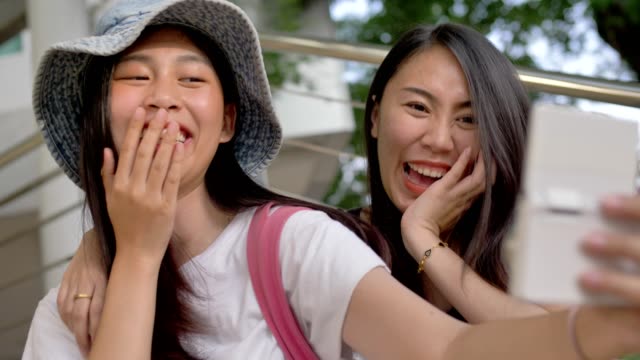 Happy-Young-Asian-girls-Smiling-And-Taking-Selfie-Photo-To-The-Camera