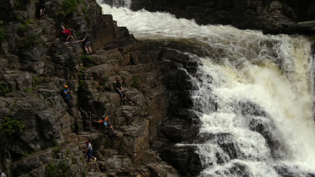 Dutzende-Bergsteiger-in-den-Bergen-neben-dem-Wasserfall