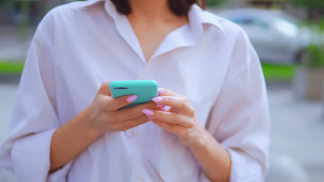 Nahaufnahme-Hände-kaukasische-Frau-hält-Smartphone-geht-Stadt-Hintergrund