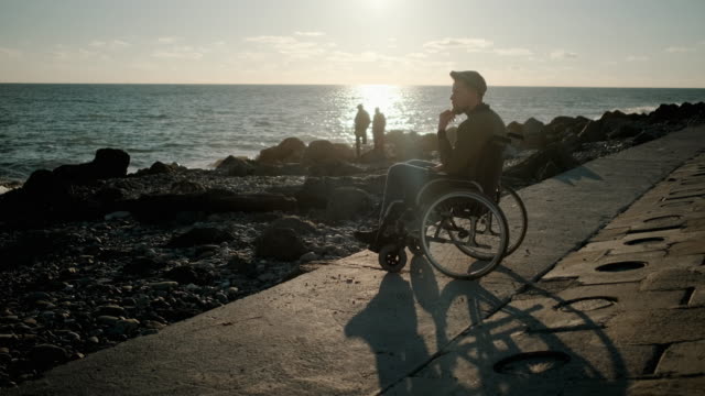 Nachdenklicher-behinderter-Mann-in-der-Nähe-des-Meeres