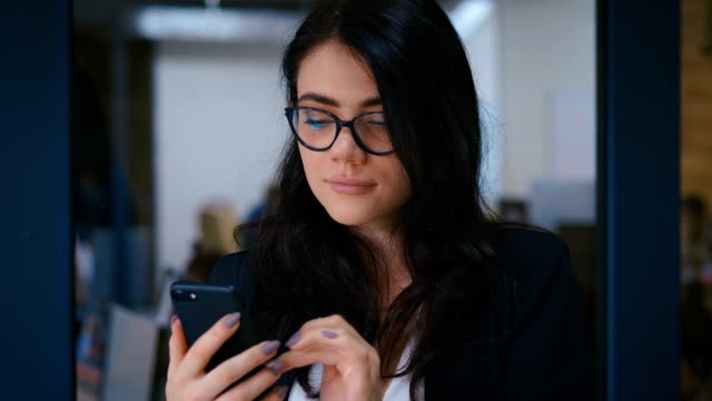 Portrait-of-Beautiful-Young-Woman-Using-Smartphone-in-Office.-Business-Lady-in-Formal-Wear-Dress-Typing-Messages-on-her-Mobile-Phone.
