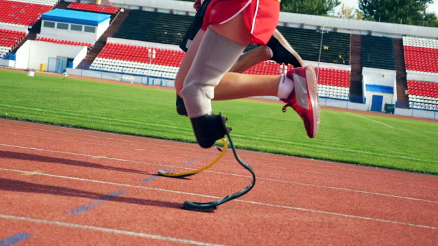 Primer-plano-de-las-piernas-artificiales-y-saludables-de-los-atletas-mientras-corre