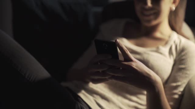 Glückliches-Mädchen-chattet-spät-in-der-Nacht-mit-ihrem-Smartphone
