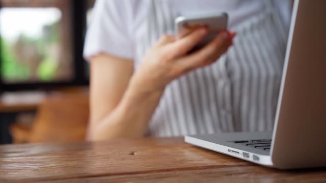 Woman-grab-smartphone-from-table-and-start-browsing-while-sitting-in-cafe