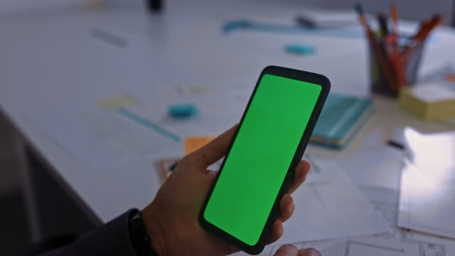 Geschäftsfrau-hält-Smartphone-Green-Screen-im-Büro