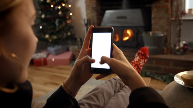 Frau-mit-Handy-im-Zimmer-bereit-für-Weihnachten