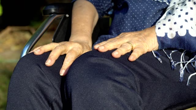 Elderly-woman-hand-on-wheelchair.