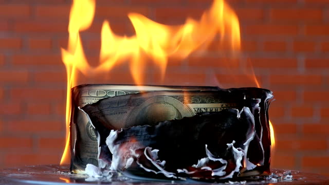 Geld-Dollar-brennen-auf-einem-Ziegelhintergrund