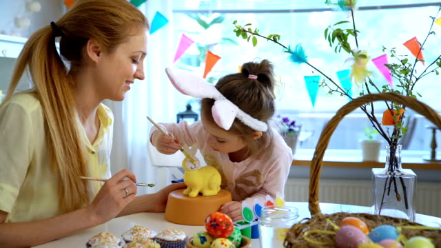 Mother-and-her-little-daughter-with-Bunny-ears-painting-Easter-Bunny