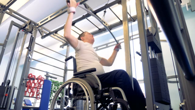 Capacitación-proceso-de-un-hombre-discapacitado-en-silla-de-ruedas-con-un-mecanismo-de-levantamiento-de-pesas