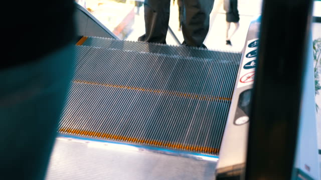 Legs-of-People-Moving-on-an-Escalator-Lift-in-Shopping-Center