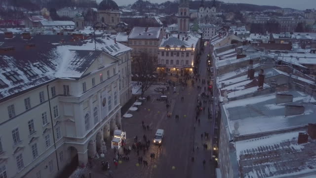 Lviv,-Ukraine---25,-December-2018.-Arial-shot.-Winter.-Rynok-square-street.-Christmas-Fair.-Lvov-Town-Hall,-City-Council.-People-are-walking-in-the-city-center.-Christmas-decorations-and-lights.-Night-time