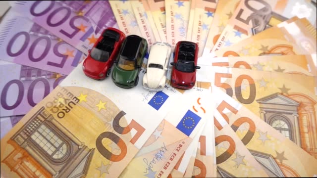 VIDEO,-small-model-cars-rotating-on-cash-euro-banknotes