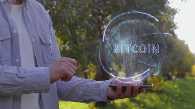 El-hombre-irreconocible-muestra-el-holograma-conceptual-con-el-texto-Bitcoin