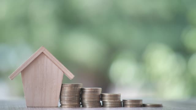Money-coin-with-wooden-house-on-nature-background.-Property-investment-and-house-mortgage-financial,-Credit-home-concept-with-copy-space