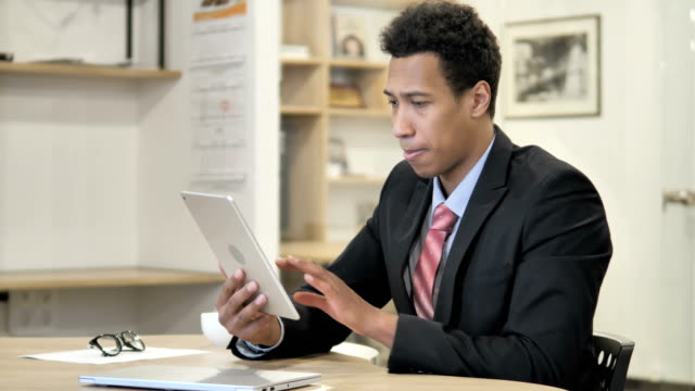 African-Businessman-Browsing-on-Tablet