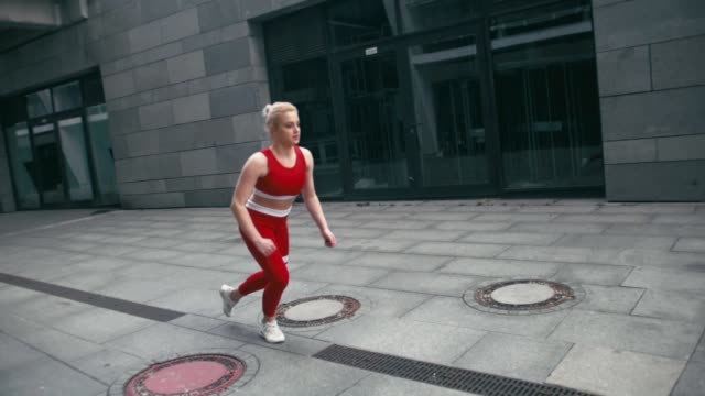 Plus-size-mixed-race-blond-smiling-woman-jogger-wearing-red-sportswear-run-fast