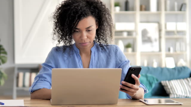 Mujer-africana-usando-smartphone-en-Workplace