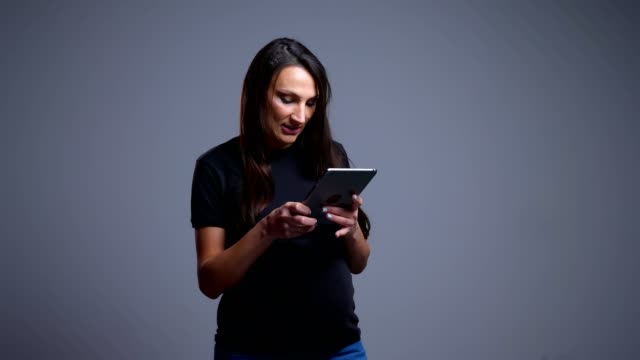 Closeup-portrait-of-pregnant-young-caucasian-woman-typing-on-the-tablet-in-front-of-the-camera