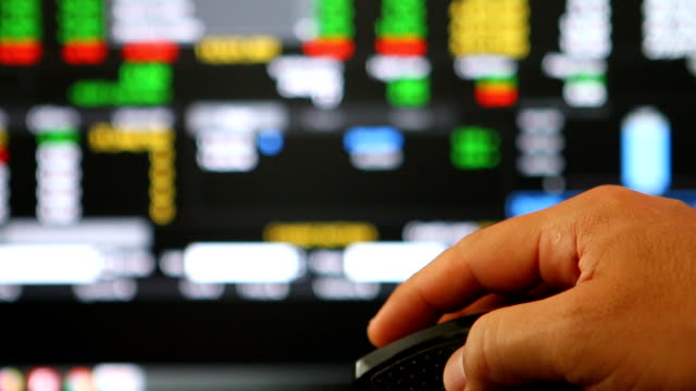 Man-clicking-mouse--to-monitoring--stock-exchange-board