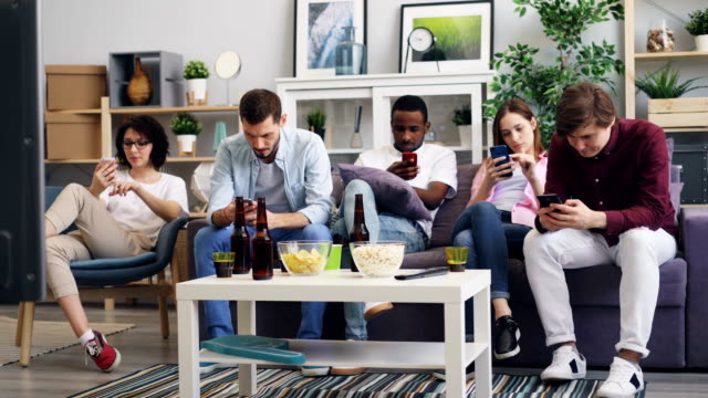 Grupo-de-jóvenes-que-utilizan-teléfonos-inteligentes-tocando-la-pantalla-en-casa-juntos