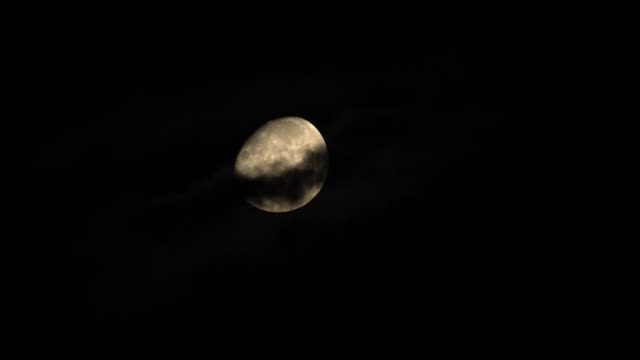 Luna-llena-detrás-de-nubes-fluidas-por-la-noche